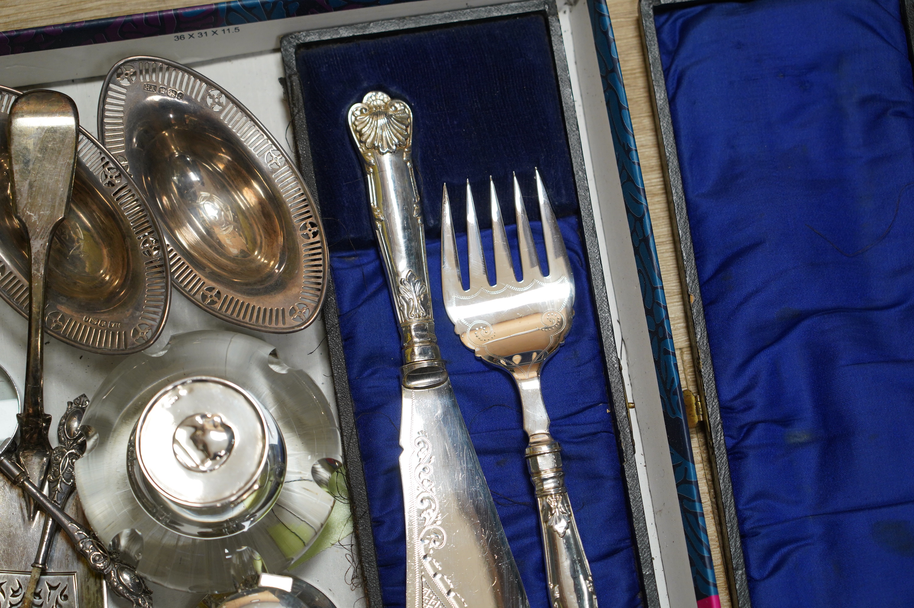 Sundry silver items including two inkwells, a William IV fiddle pattern fish slice, a pair of bonbon dishes and two handled magnifying glasses (one a.f.), together with a cased pair of plated fish servers. Condition - po